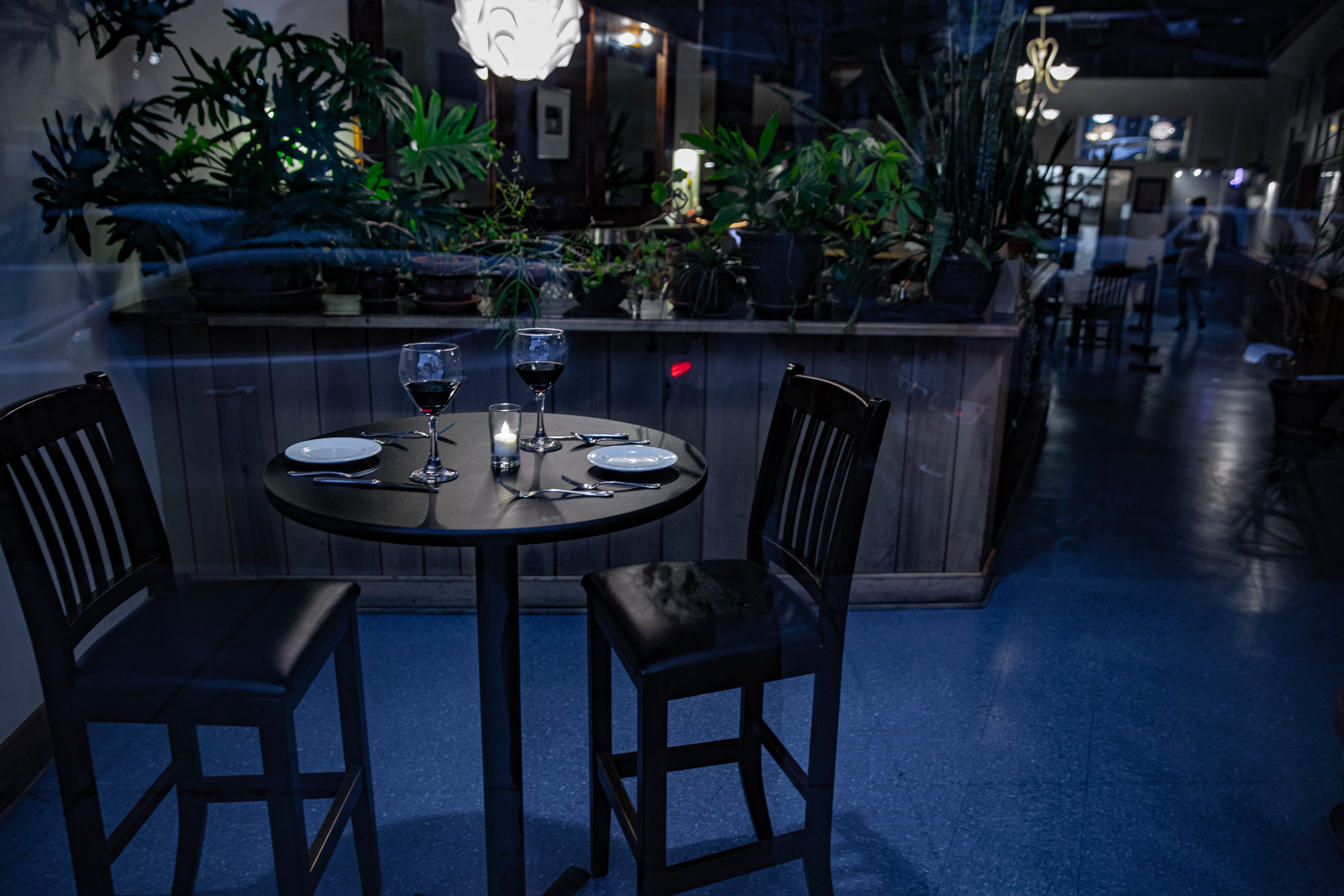 an empty dining table at Zoe with a view of the plants on the bar behind it